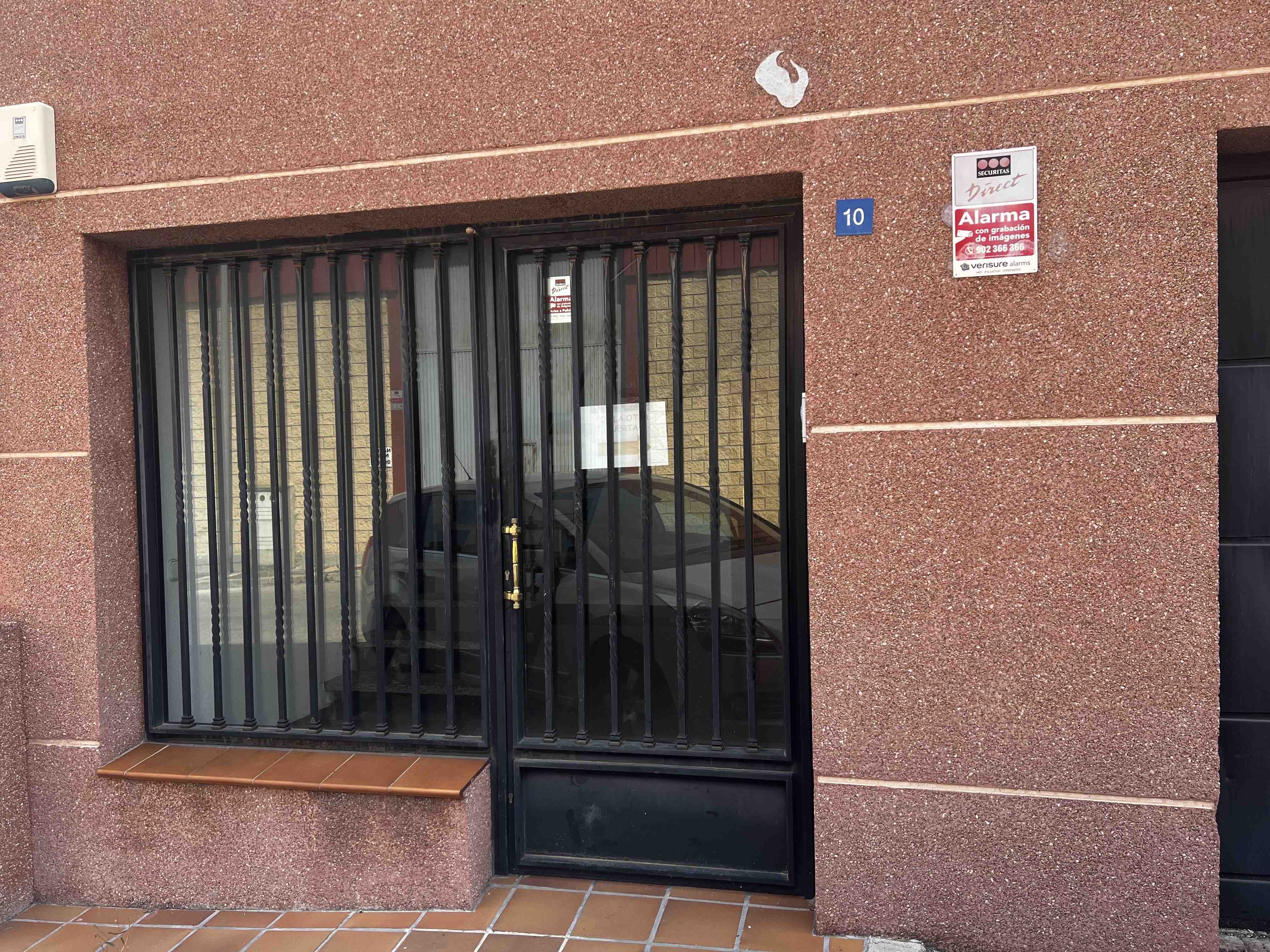 Entrada de edificio con rejas y número 10